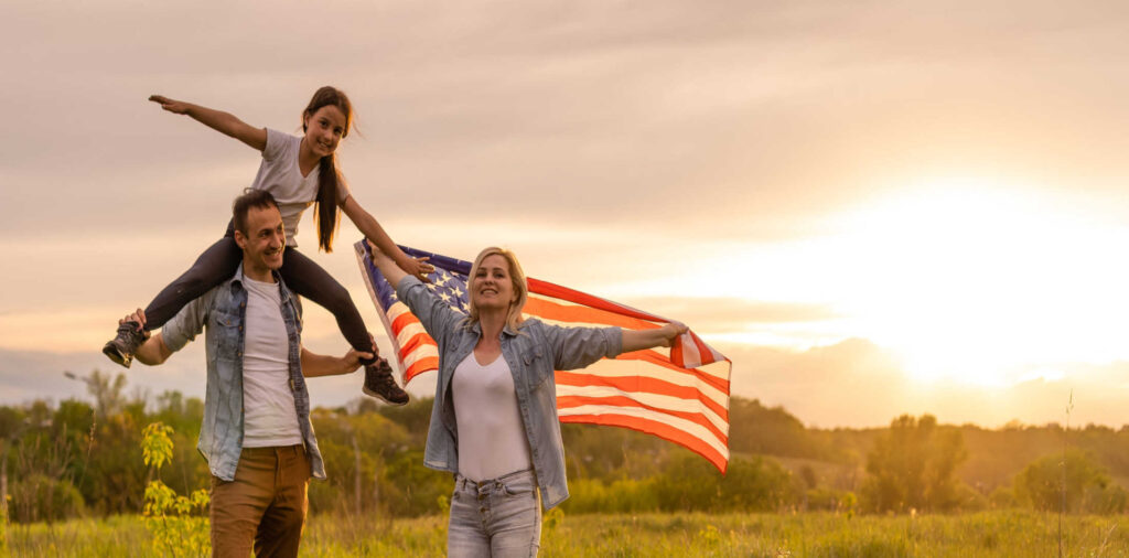 family outdoors with flag